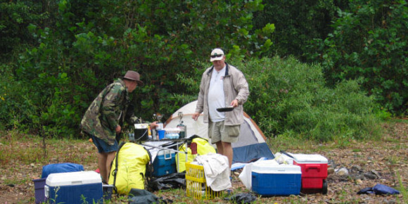Photo of Mark Trew cooking breakfast in the rain at Sebowisha on the Caney Fork River and Smith Fork Creek