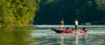 A pair of bass fisherman in a red bass boat catch a bass on Great Falls Lake